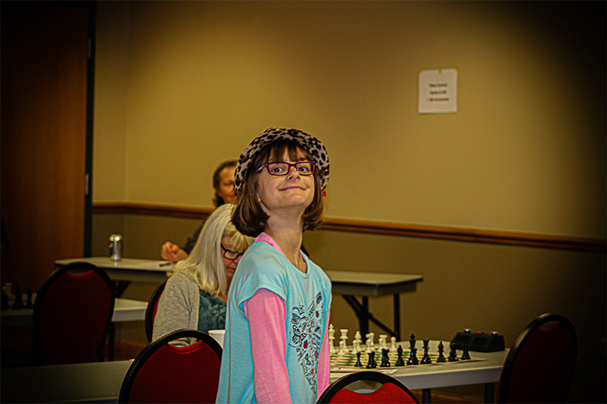 Rookie Elizabeth Braddy, playing in only her fourth rated tournament, contributed to Oklahoma's victory by sweeping her Board 22 opponent.  Later she had a great time at the Bug House tournament.  Photo by Sheryl McBroom.